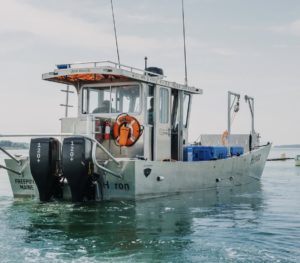 Maine Ocean Farm's electric boat on calm waters powered by Evoy electric outboard motor